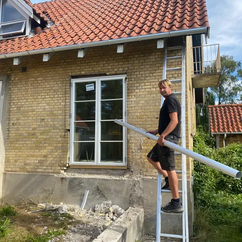 Claus, indehaver af Aktiv Rens, på stigen under en tagrens