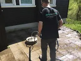 Aktiv Rens medarbejder i gang med professionel fliserens af terrasse