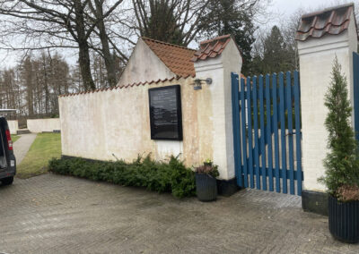 Igangværende rensning af hvid kirkemur indgang i Fredensborg.